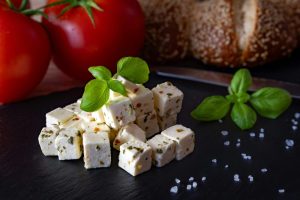Savor the Mediterranean flavors of cubed cheese with tomatoes and fresh basil, perfect for a nutritious snack.