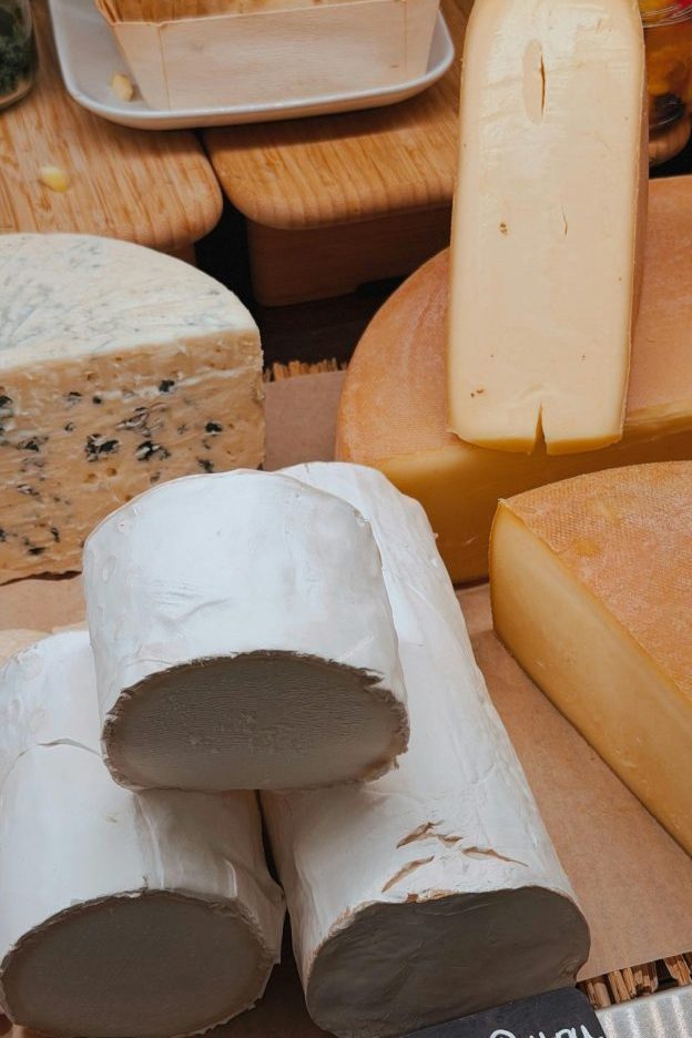 A variety of French cheeses including Bûche du Poitou, showcasing texture and variety.