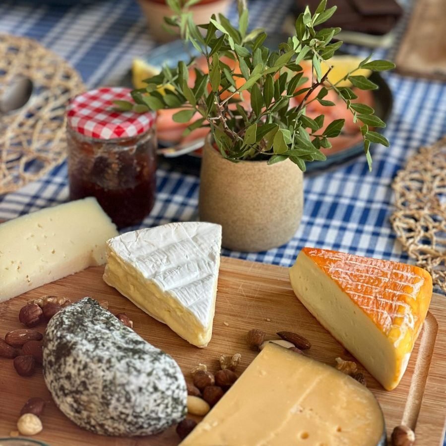 A rustic breakfast table spread with assorted cheeses, jam, and nuts, perfect for a cozy brunch setting.